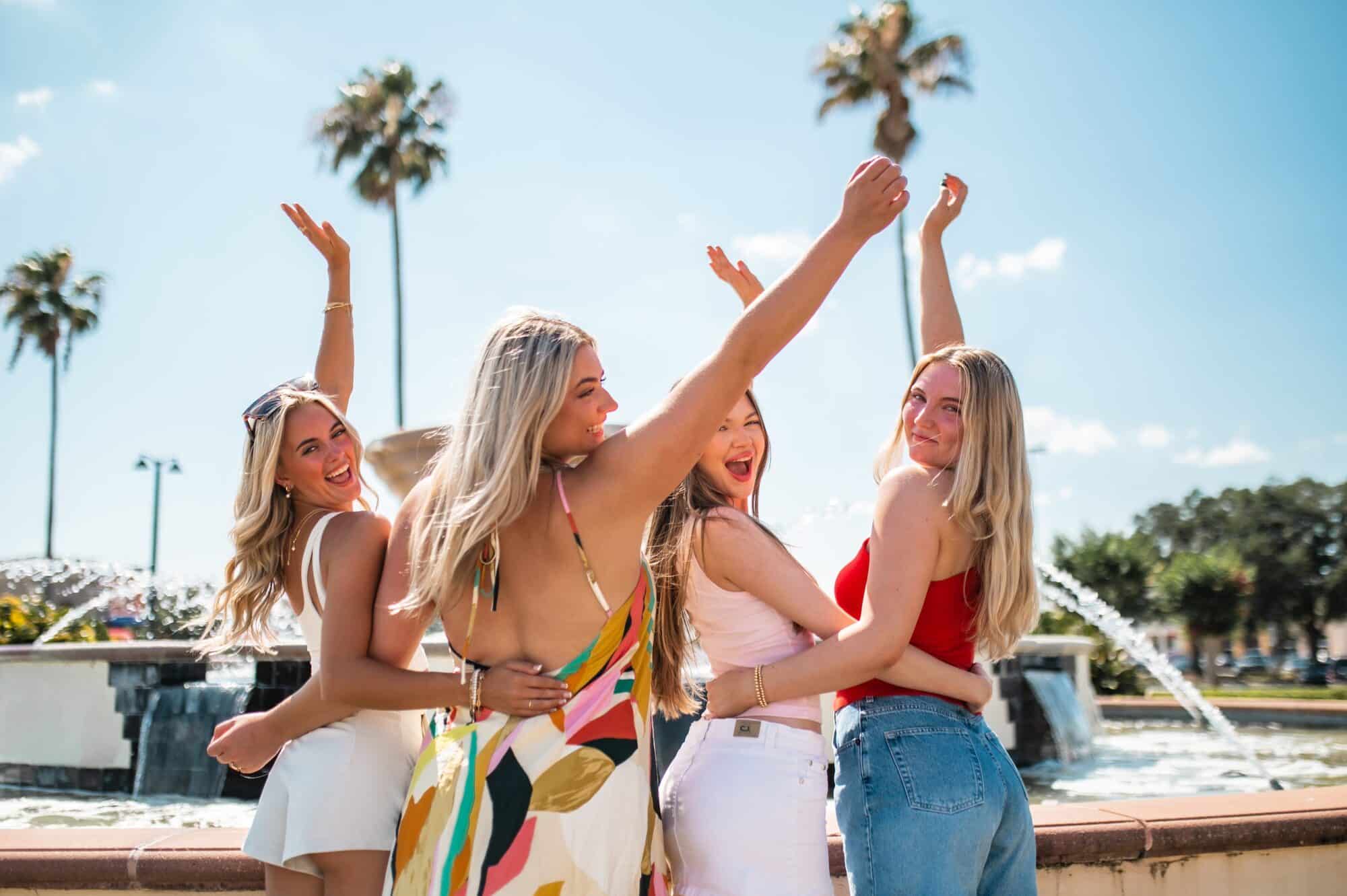 girls celebrating in front of fountain